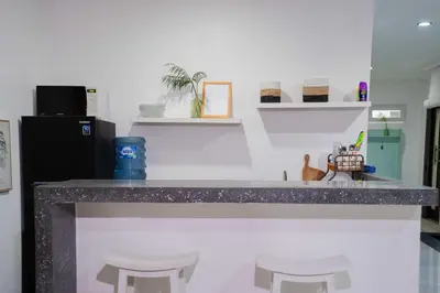 a kitchen with a counter with stools and a refrigerator at Massive 3 bedroom villa in heart of Seminyak in Seminyak
