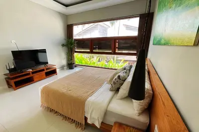 a bedroom with a bed and a large window at Modern spacious private pool villa in Central Canggu in Canggu