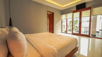 a bedroom with a bed in a room with windows at Modern spacious private pool villa in Central Canggu in Canggu