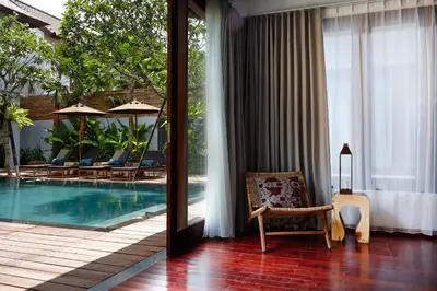 a hotel room with a pool and a chair next to a window at Villa Ziba in Seminyak