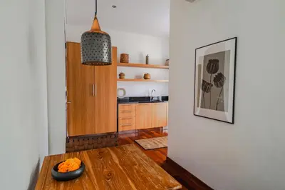 a living room with a table and a kitchen at Villa Ziba in Seminyak