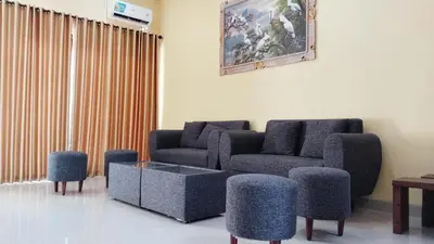 a living room with two couches and a table and chairs at Tambak Sari Villa in Jimbaran