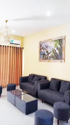 a living room with couches and a table and chairs at Tambak Sari Villa in Jimbaran