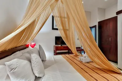 a bedroom with a bed with a canopy at Villa Taksu Legian in Legian