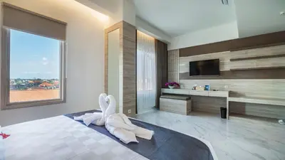 a bedroom with a bed with a towel animal on it at City of Aventus Hotel - Denpasar in Denpasar