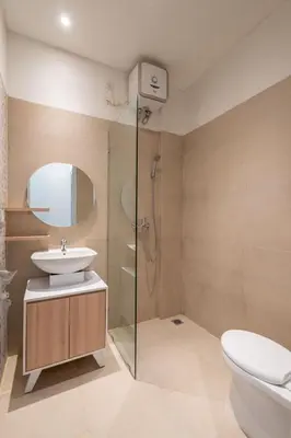 a bathroom with a toilet and a sink and a shower at Ellavie Aparthouse Kerobokan in Kerobokan