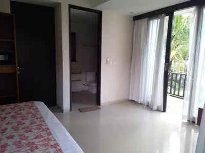 a bedroom with a bed and a bathroom with a toilet at LBV Seminyak Apartment in Seminyak
