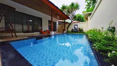 a swimming pool in front of a house at Private Pool Villas Kuta Bali in Kuta