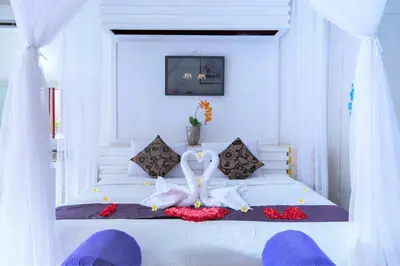 a bedroom with a white bed with two swans on it at Private Pool Villas Kuta Bali in Kuta