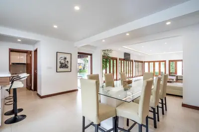 a dining room with a glass table and chairs at Vienna Villas by Great Bali Villas in Seminyak