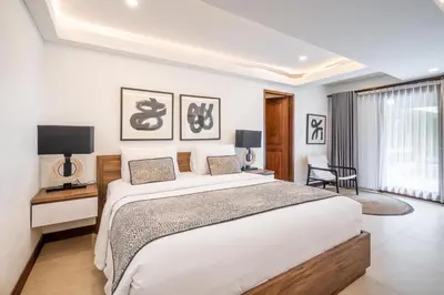 a white bedroom with a large bed and a tv at Vienna Villas by Great Bali Villas in Seminyak