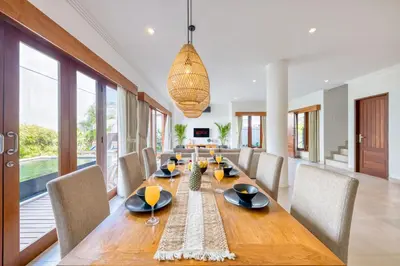 a dining room with a long wooden table and chairs at Freshly Renovated 3 BD Homey Central Villa in Seminyak
