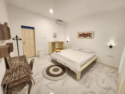 a bedroom with a bed and a chair in it at Capricorn Villa in Seminyak
