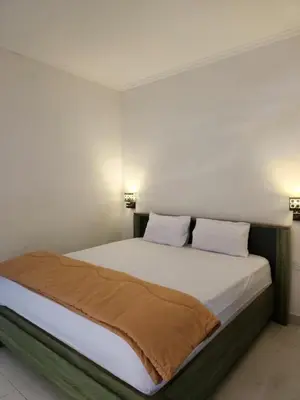 a bedroom with a bed with white sheets and pillows at Capricorn Villa in Seminyak