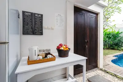 a table with a bowl of fruit on it next to a door at Villa Putih Jimbaran in Jimbaran