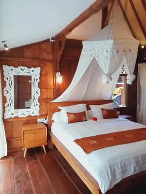 a bedroom with a bed with a canopy at Buratwangi Joglo House in Kerobokan