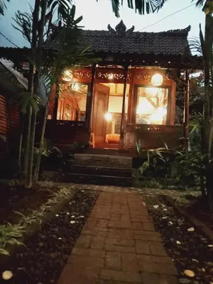 a house in the middle of a garden at night at Buratwangi Joglo House in Kerobokan