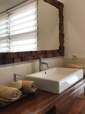 a bathroom with a white sink and a mirror at 2 BR Pepper House Villa near GWK Jimbaran - garden view in Jimbaran
