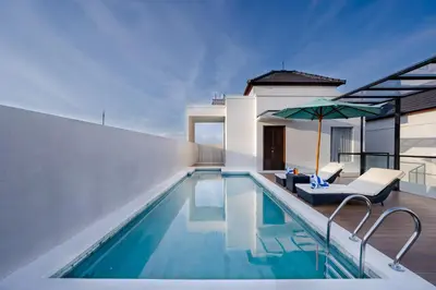 a swimming pool with a chair and an umbrella at Canggu Villa Go by Nagisa Bali in Canggu