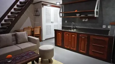 a living room with a couch and a kitchen at Alu Lofts in Seminyak