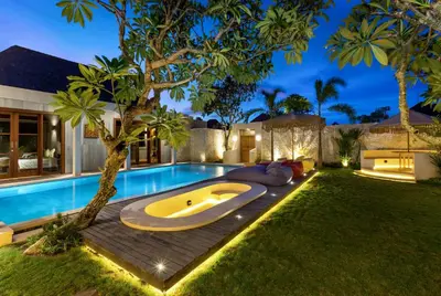 a swimming pool with a tub in a yard at Navya Villas in Canggu