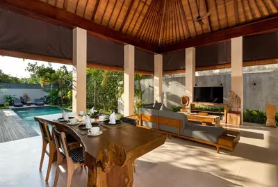 an outdoor dining room with a table and a couch at Navya Villas in Canggu