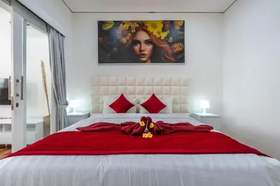 a bed with a red blanket and a stuffed animal on it at Luxury minimalist villa Nobu in Seminyak in Seminyak