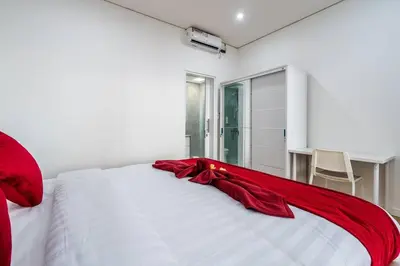 a red blanket laying on top of a white bed at Luxury minimalist villa Nobu in Seminyak in Seminyak