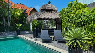 a resort with a swimming pool and two chairs and a hut at Villa Ruku-Ruku - Modern 1BR Villa with AC Living Room & Private Pool - French Style Interior in Kerobokan