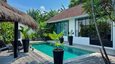 a villa with a swimming pool and a resort at Villa Ruku-Ruku - Modern 1BR Villa with AC Living Room & Private Pool - French Style Interior in Kerobokan