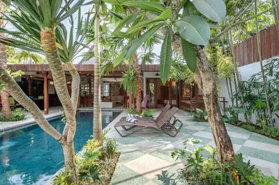 a resort with a pool and palm trees at Villa Gambar - Comfortable Modern Mix 3BR Villa with Large Private Pool, 10 Minutes to the Beach in Canggu