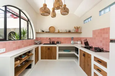 a kitchen with pink tile and wooden cabinets at Casa Adem - Modern & Trendy 3BR Villa in Seminyak, 10 Minutes to the Beach with Private Pool in Seminyak