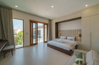 a bedroom with a king sized bed and a couch at Villa Umaju - Contemporary Minimalist 2BR Villa in Umalas! in Canggu