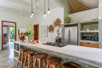 a kitchen with a counter with stools around it at Villa Telma - Charming 2BR Villa in Central Seminyak, Walking Distance to Eat Street in Seminyak