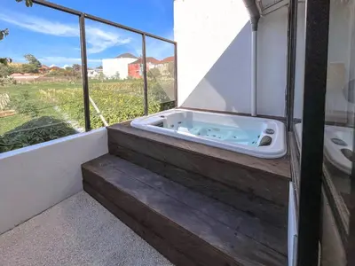 a jacuzzi tub on a balcony with a view at House Sawah - Beautiful & Stylish 3BR Home with Jacuzzi Near Umalas and Seminyak in Kerobokan
