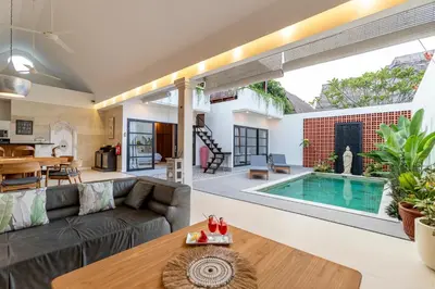 a living room with a couch and a swimming pool at Villa Elea - Bright & Modern 2BR Villa in Seminyak with Private Pool and Sunset Rooftop in Seminyak