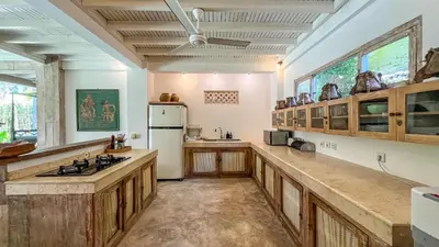 a large kitchen with wooden cabinets and a white refrigerator at Villa Nak - Charming 4BR Family-Friendly Villa, Walking Distance to Seminyak Beach in Seminyak
