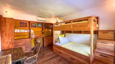 a bedroom with two bunk beds and a desk at Villa Nak - Charming 4BR Family-Friendly Villa, Walking Distance to Seminyak Beach in Seminyak