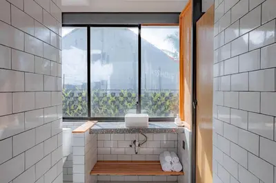 a bathroom with a window with a laptop on a counter at Town House REX in Kuta