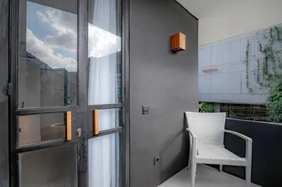 a white chair sitting next to a glass door at Town House REX in Kuta
