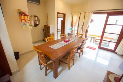 a dining room with a wooden table and chairs at Vibrant Getaway in Seminyak: Villa Buyaya in Seminyak
