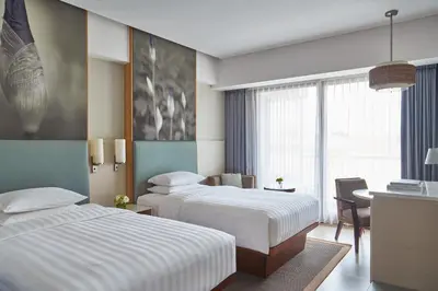 a hotel room with two beds and a desk at Courtyard by Marriott Bali Seminyak Resort in Seminyak