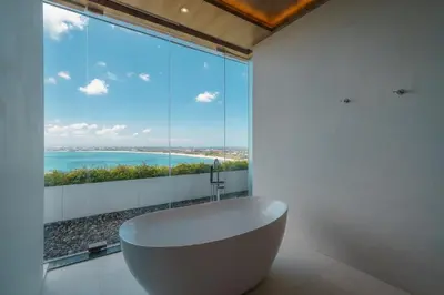 a bathroom with a tub in front of a large window at Beyond The Sea - Luxe Sea View Villa in Jimbaran in Jimbaran