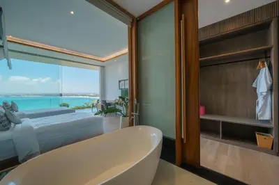 a bathroom with a tub and a bedroom with a view at Beyond The Sea - Luxe Sea View Villa in Jimbaran in Jimbaran