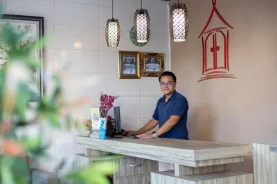a man standing at a counter in a coffee shop at Angkul Angkul Beach Inn Kuta by Kamara in Kuta
