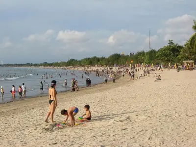 a group of people on a beach at Angkul Angkul Beach Inn Kuta by Kamara in Kuta