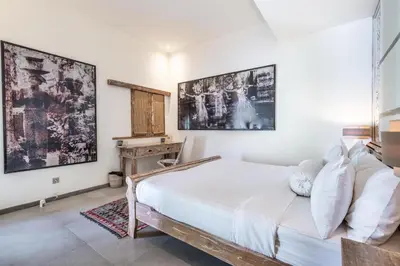 a bedroom with a large bed and a desk at Villa Oberoi in Seminyak