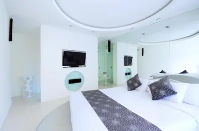 a white bedroom with a large bed and a tv at 4BR Villa Minggu - Minggu Villas Seminyak in Seminyak