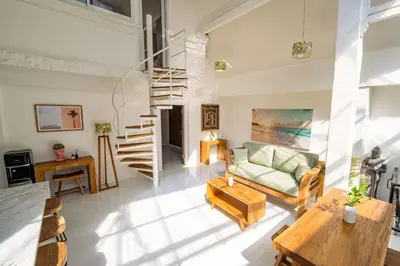 a living room with a couch and a spiral staircase at Spacious 3 BR Villa with private pool and Billiards in Seminyak