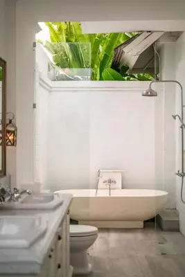 a bathroom with a sink and a toilet and plants at Beachside Colonial Elegance: 4BR in Canggu in Canggu